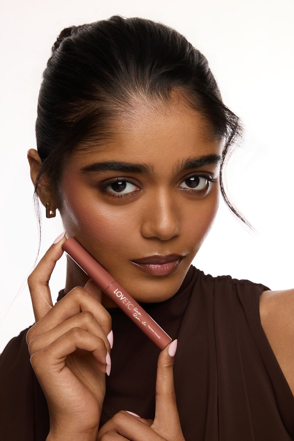 Beauty portrait with the LOVETC lip conditioner held to camera